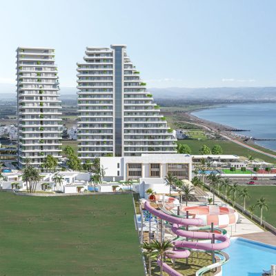 Yüzme havuzu ve plajı olan bir apartman kompleksinin görüntüsü.