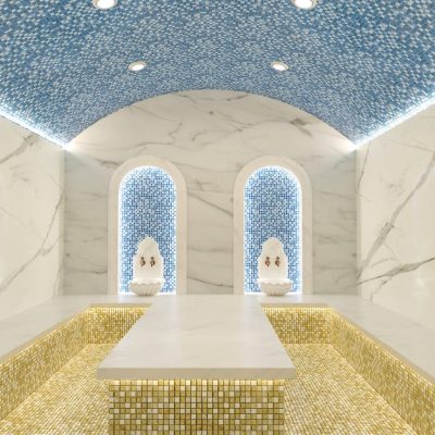 Mavi ve beyaz fayanslı duvarlara sahip bir banyo.